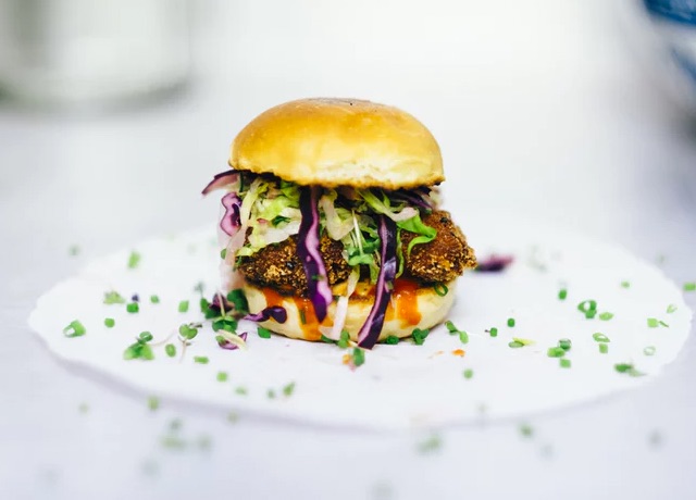 photo of a veggie burger garnished with cabbage on a plate
